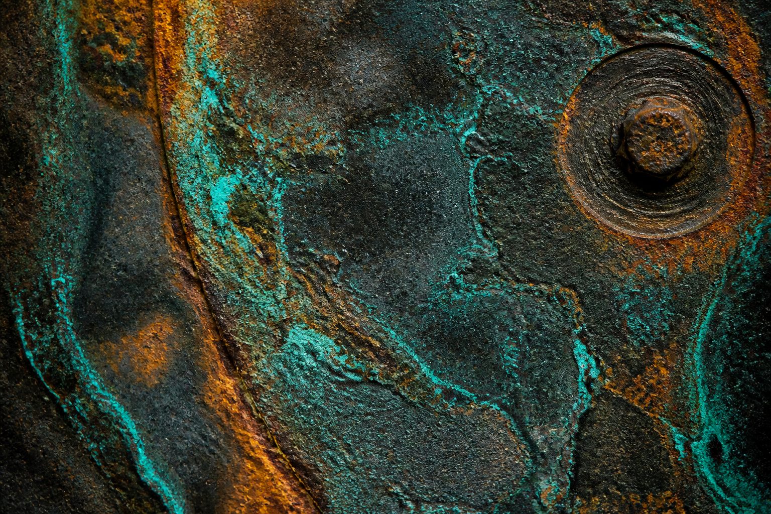 Oxidised metal surface, copper-teal corrosion tracing the boundaries where conditions have acted on it over time