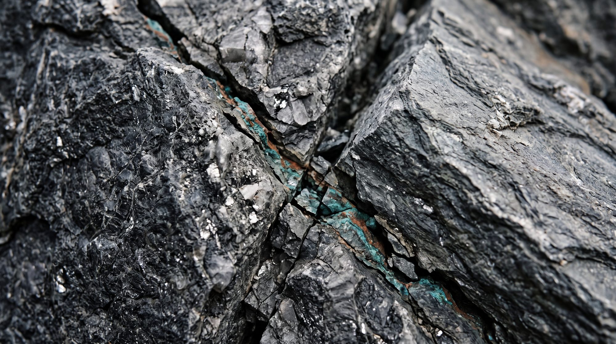 Rock face where two lines in the strata converge, a thin oxidised vein running along the seam